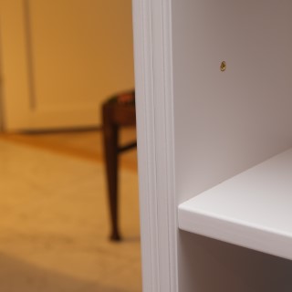 Närbild av hyllplan i vit bokhylla
